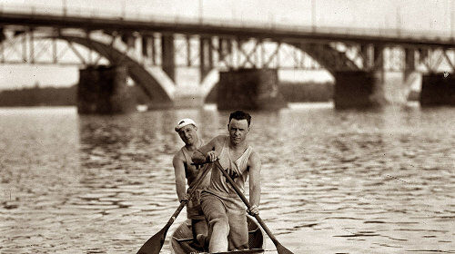 Two people canoeing, experiencing both inside dry and outside wet conditions.