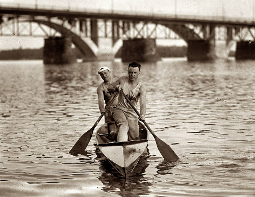 Two people canoeing, experiencing both inside dry and outside wet conditions.