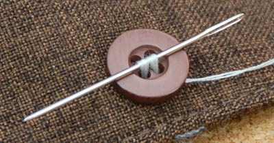 Thread passed through the button's holes by needle.