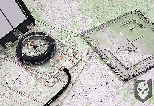 A compass on top of a topographic map.
