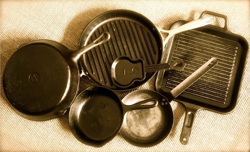 Assortment of cast iron skillets round square.