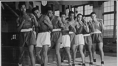 Black and white photo of a group of fighters posing during a workout.