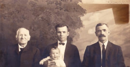 A photo showing three men holding a baby, capturing the essence of generations.