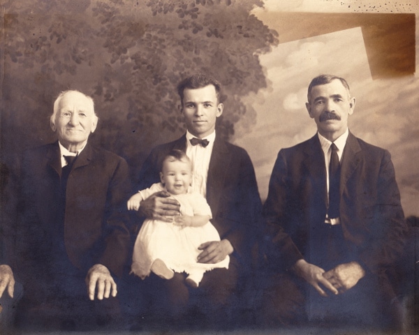 A photo showing three men holding a baby, capturing the essence of generations.