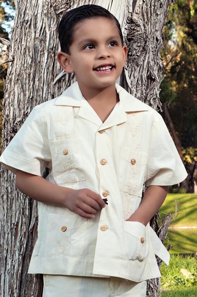 Young boy wearing beige tan guayabera shirt.