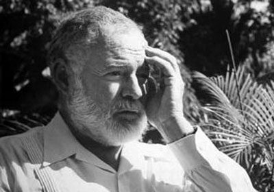 A black and white photo of a man with a beard, dressed sharp in a Guayabera shirt.