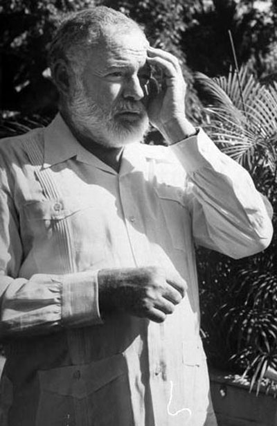 A black and white photo of a man with a beard, dressed sharp in a Guayabera shirt.