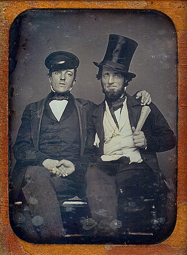 Vintage two men are siting wearing hats black and white photo illustration.