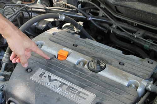 Man pointing on an I-VTEC engine of car.