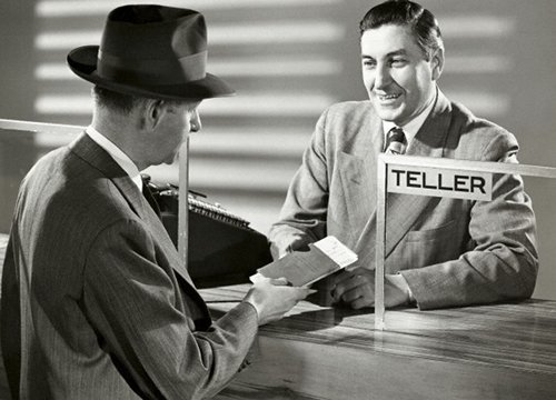 Vintage bank teller helping customer.