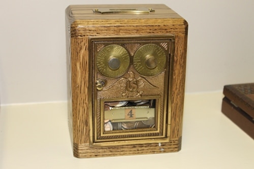 Vintage coin bank made with door of old post office box.