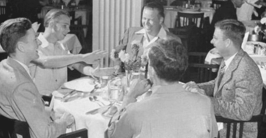 A group of young men sitting around a table.