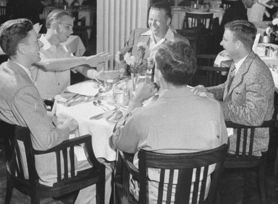 A group of young men sitting around a table.