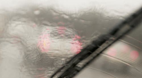 Water smearing on windshield blurry photo of glass.