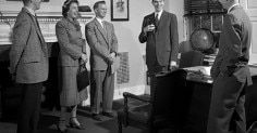 How small talk helps a group of people standing in front of a desk.