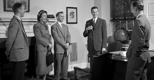 How small talk helps a group of people standing in front of a desk.