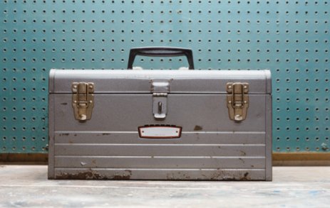 Gray worn toolbox teal checkerboard behind.