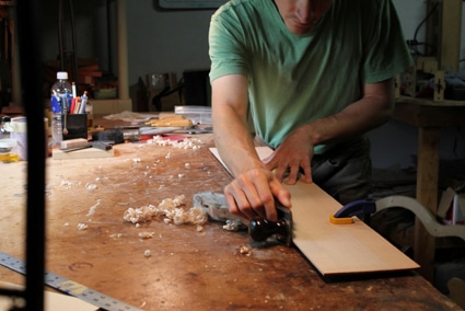 Luthier guitar maker working on making instrument. 