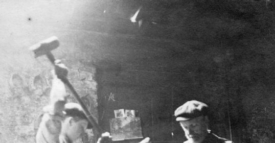 Two men working in Longfellow's Blacksmith shop, where lessons learned forge their skills.