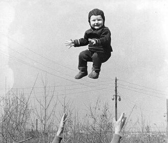 A fitness-minded dad flies a child in the air.