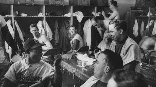 A group of men, baseball players, in a locker.
