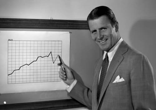 Vintage businessman smiling and drawing line graph chart on board.