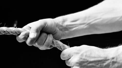 A forgetful man captured in a striking black and white photograph, tightly holding fast to a rope.