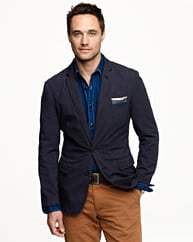 Man wearing blazer with blue shit and khaki pant.