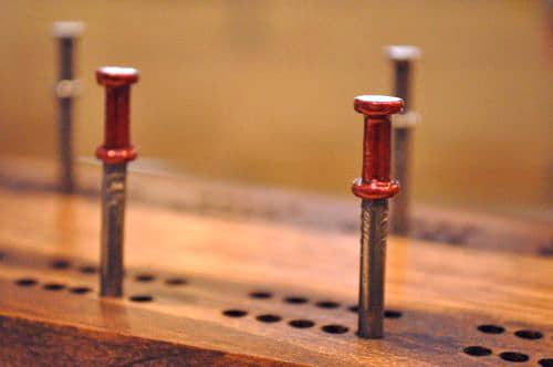 DIY wooden cribbage board with nails.