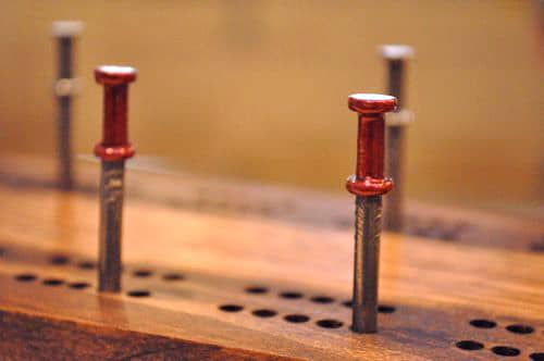 DIY Cribbage Board aus Holz mit Nägeln.