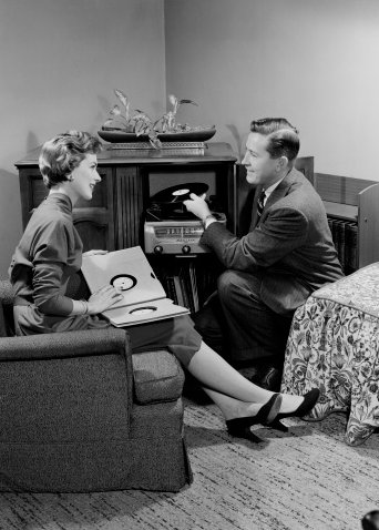 Man and women chatting in pleasant mood and selecting records for turn table.