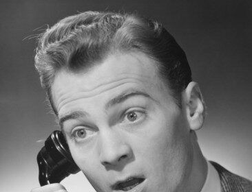 An obvious black and white photo of a man on a call.