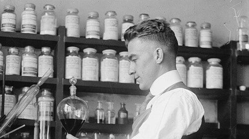 A man in an apron conducting tests in a laboratory to measure normal levels of Testosterone.