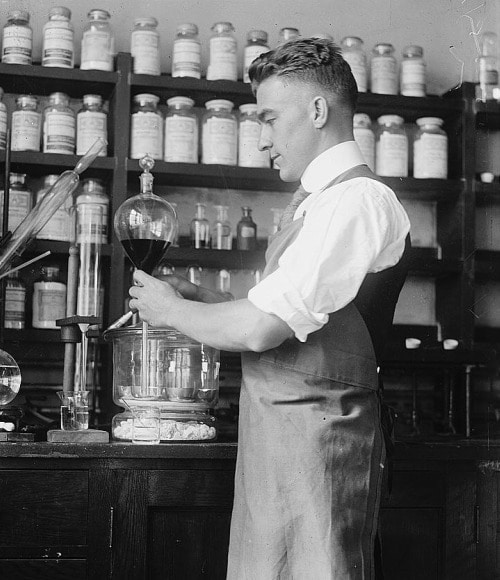 A man in an apron conducting tests in a laboratory to measure normal levels of Testosterone.