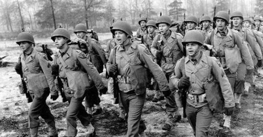 A group of soldiers confidently undertaking a 20 Mile March through a field.