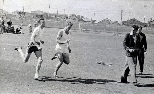 An old photo capturing men engaged in distance running across a field, shrouded in myths.