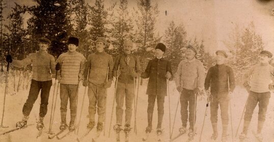 A group of skiers wearing Men's Winter Hats posing for a picture.