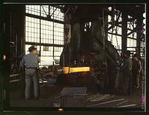 Vintage metal workers in workshop melting heating metal. 