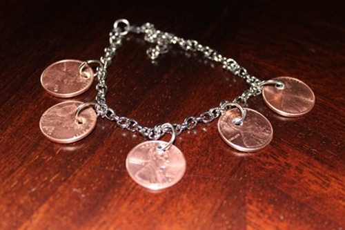 A DIY Penny Charm Bracelet with four coins on it.