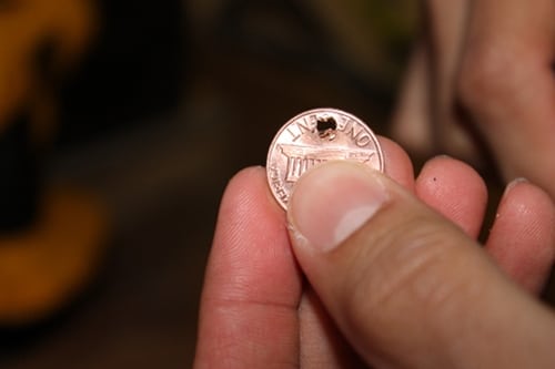Hole drilled in top of penny for diy charm bracelet. 