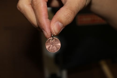 Small jump ring through hole in penny for diy charm bracelet. 