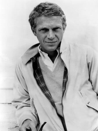 Steve Mcqueen lookiing cool in layering and holding tobacco pipe.