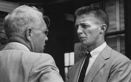 Two men in suits having a conversation.