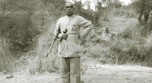 A man standing next to a dead tiger, showcasing his expertise in dealing with Man-Eaters.