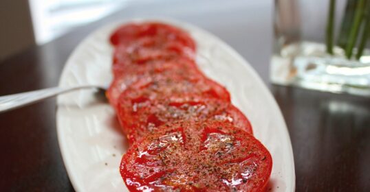 Quick sliced tomatoes on a white plate.