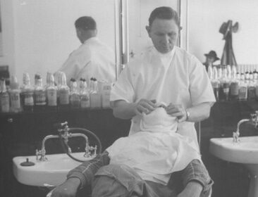 Create a Barbershop experience with a man getting a haircut and enjoying the soothing sensation of a hot towel.
