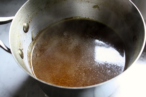 Place the strained pot of liquid back on the stove over medium-high heat, allowing the mixture to reach a boil in order to reduce by at least half – you should have about 2-3 cups of liquid remaining. Remove from heat, cover, and keep warm for service.