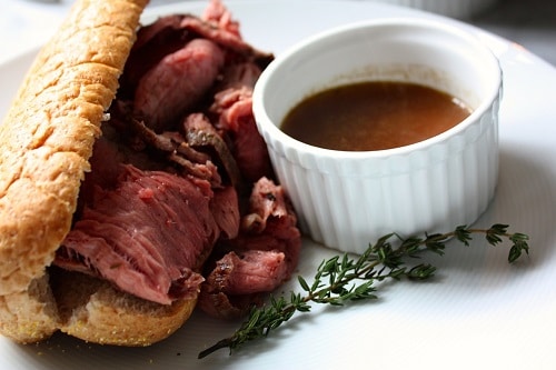 Remove warmed bread from oven and pile high with roast beef. Serve alongside warmed au jus for dipping.