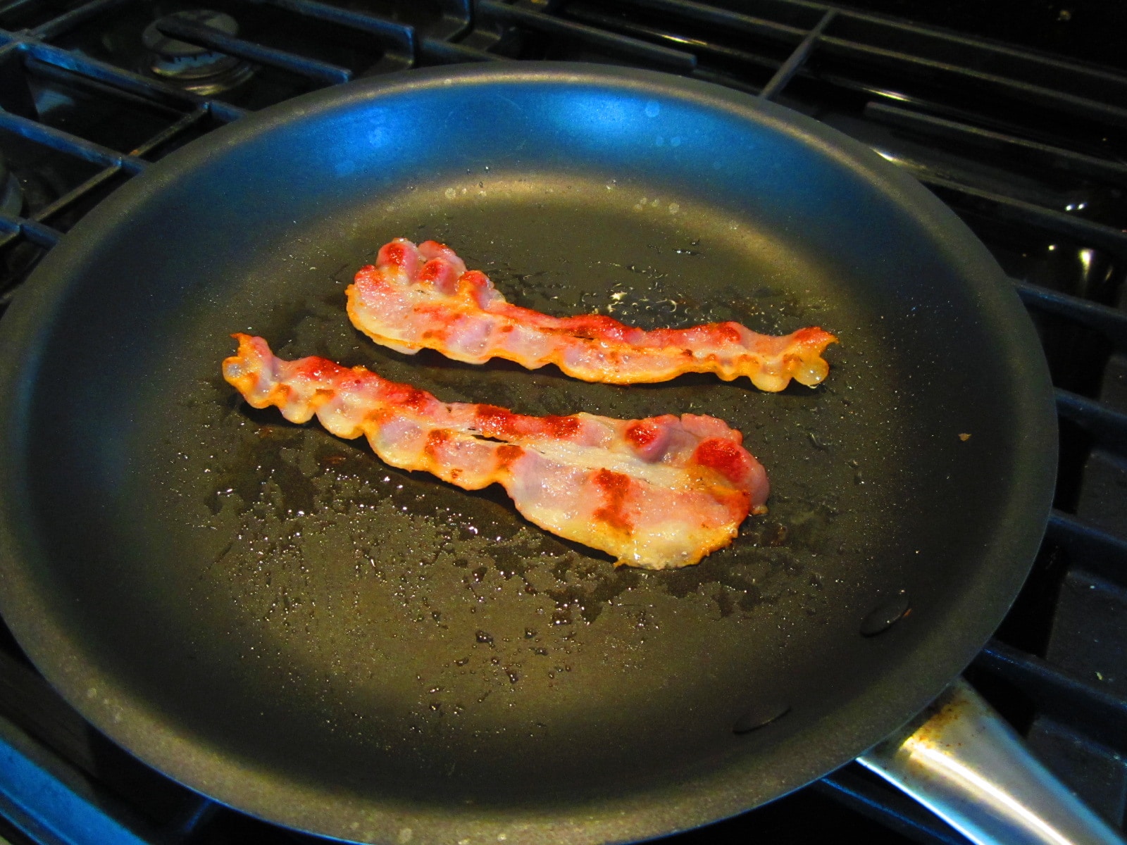 Vintage frying bacon into pan.