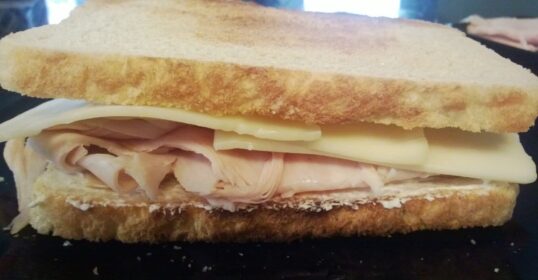 A sandwich with turkey and cream cheese on a plate.